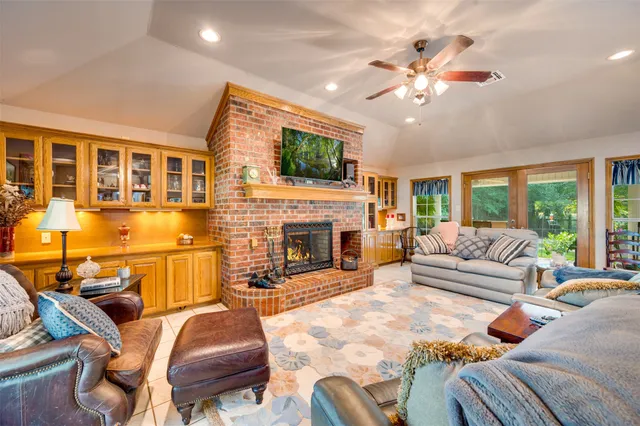 a living room with furniture a fireplace and a flat screen tv