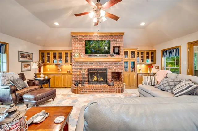 a living room with furniture a fireplace and a flat screen tv