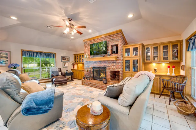 a living room with furniture a fireplace and a flat screen tv