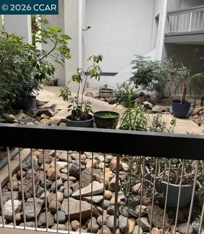 a view of a backyard with brick wall and potted plants