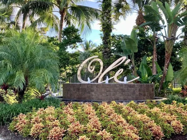 front view of a wooden house with a yard and large trees