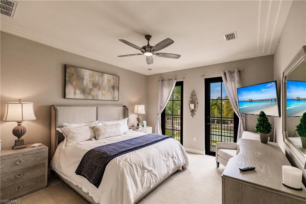 9081 Albion Lane South, Unit 6502 Naples, FL 34113 - Photo 22 of 37 a bedroom with a large bed and a chandelier