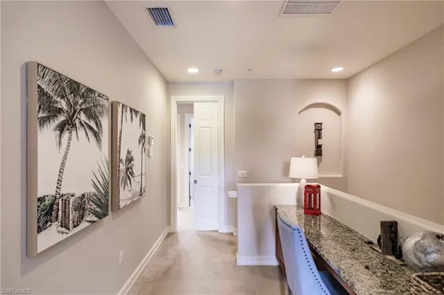 a view of a hallway with stairs and furniture