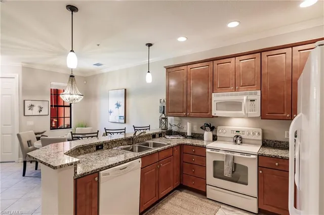 a kitchen with stainless steel appliances granite countertop a sink refrigerator and cabinets