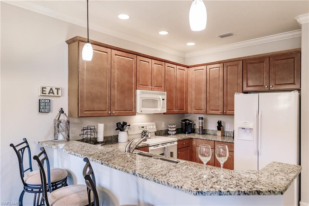 9081 Albion Lane South, Unit 6502 Naples, FL 34113 - Photo 31 of 37 a kitchen with stainless steel appliances granite countertop a sink refrigerator and cabinets