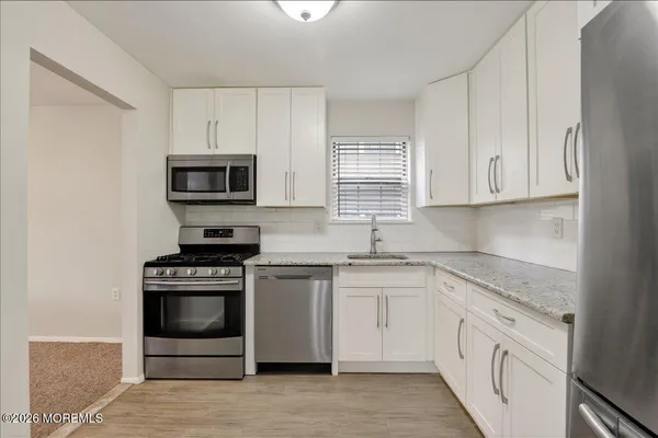 a kitchen with cabinets stainless steel appliances and window