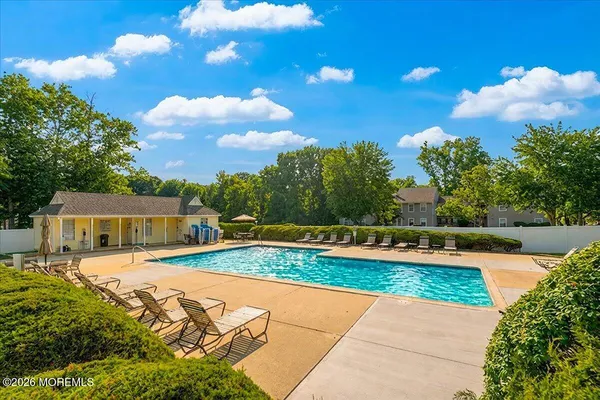 a view of small swimming pool with a yard and plants