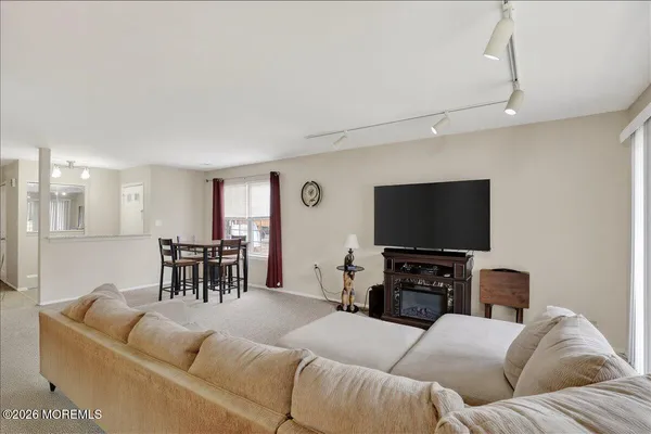 a living room with furniture a large window and gym equipment