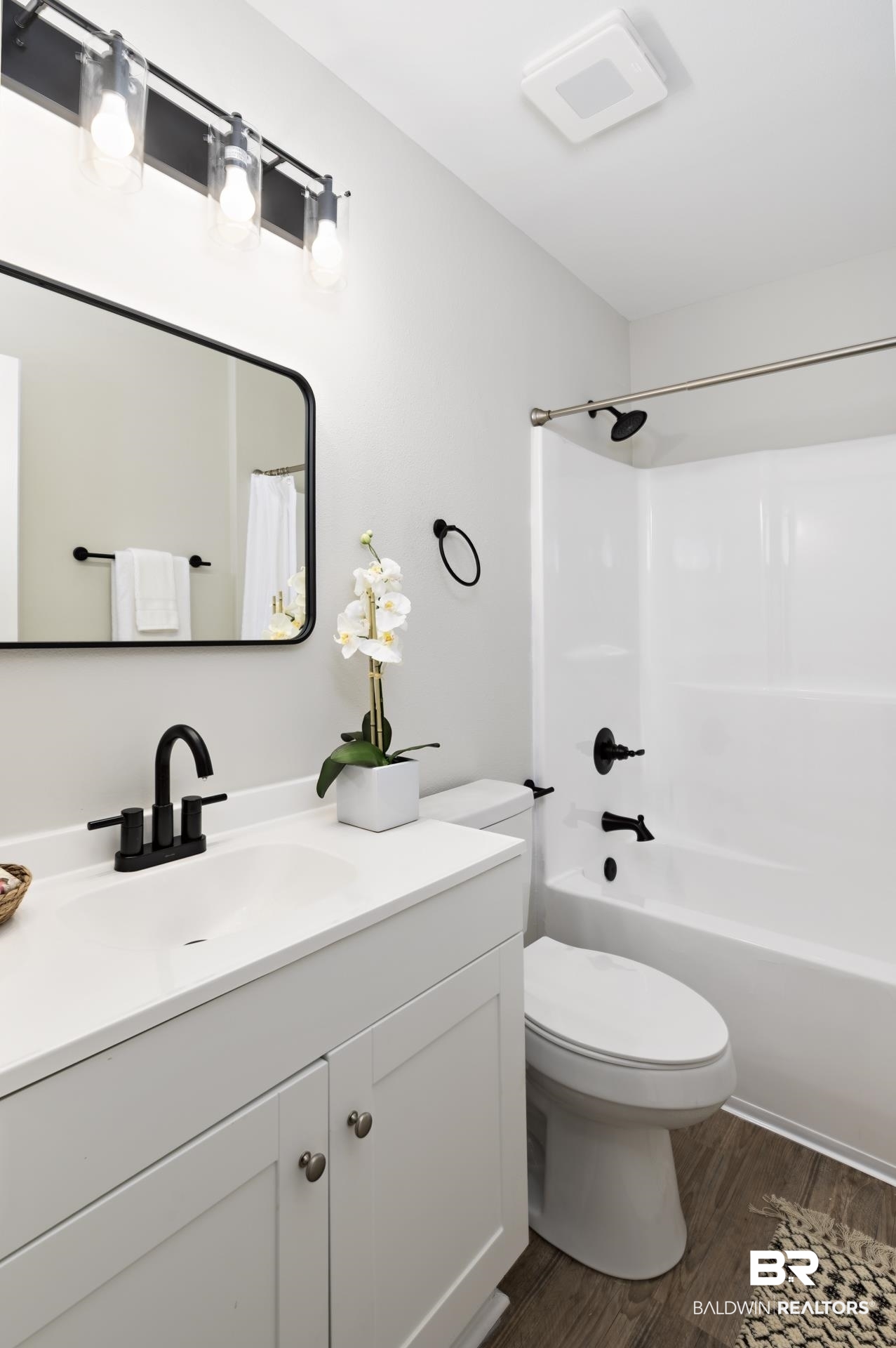 21717 Shadowbrook Street Robertsdale, AL 36567 - Photo 15 of 32 Bathroom featuring shower / bathtub combination with curtain, vanity, toilet, and wood finished floors