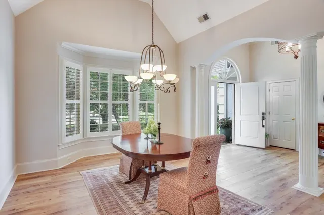 a dining room with furniture a chandelier and wooden floor