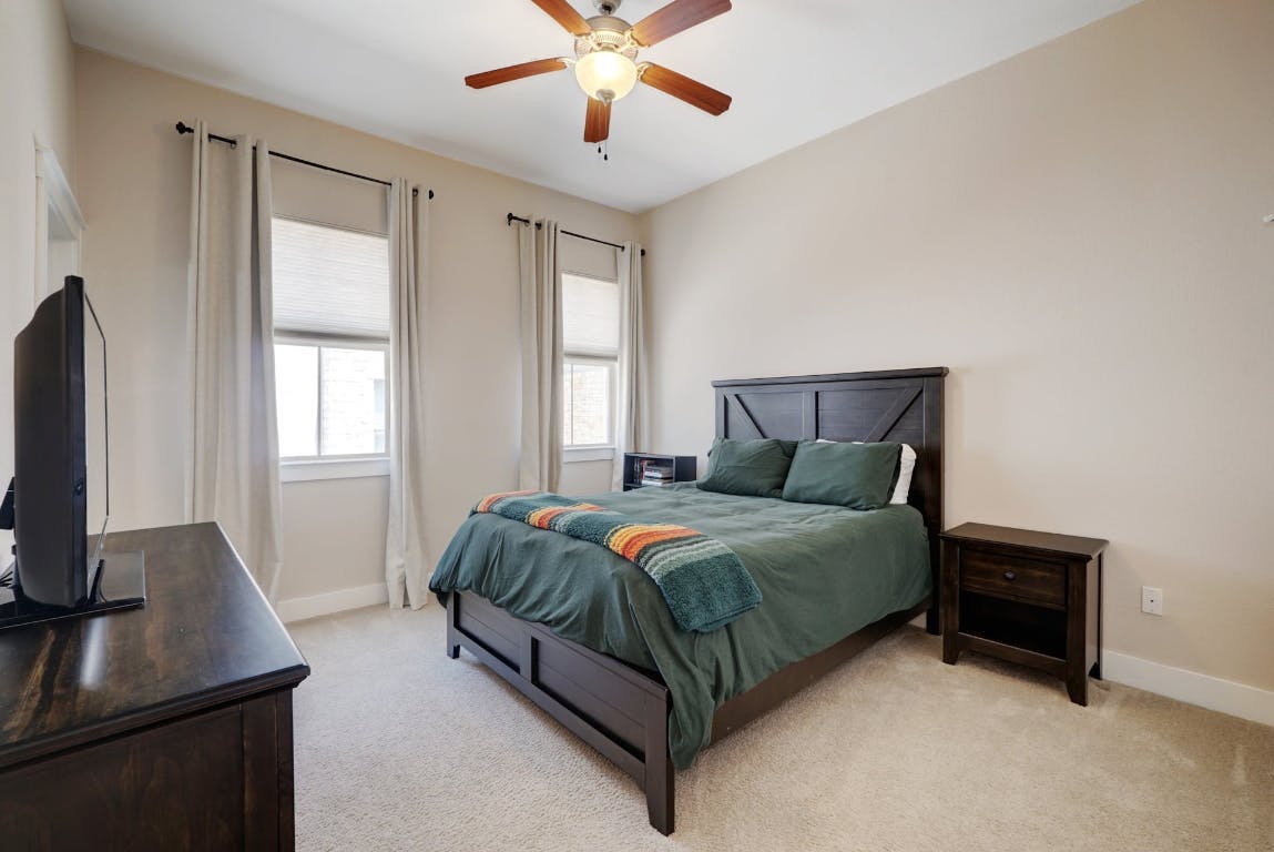 2520 Bluebonnet Lane, Unit 41 Austin, TX 78704 - Photo 18 of 30 a bedroom with a bed and a flat tv screen on the dresser
