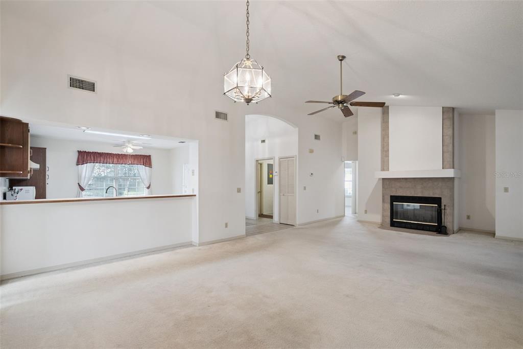 1193 Glen Falls Road DeLand, FL 32720 - Photo 5 of 20 a view of a livingroom with a fireplace a chandelier and windows
