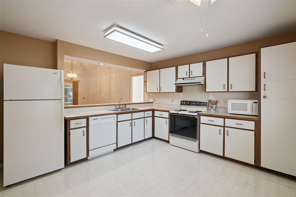 1193 Glen Falls Road DeLand, FL 32720 - Photo 9 of 20 a kitchen with stainless steel appliances granite countertop white cabinets a refrigerator a sink a stove a microwave and white cabinets