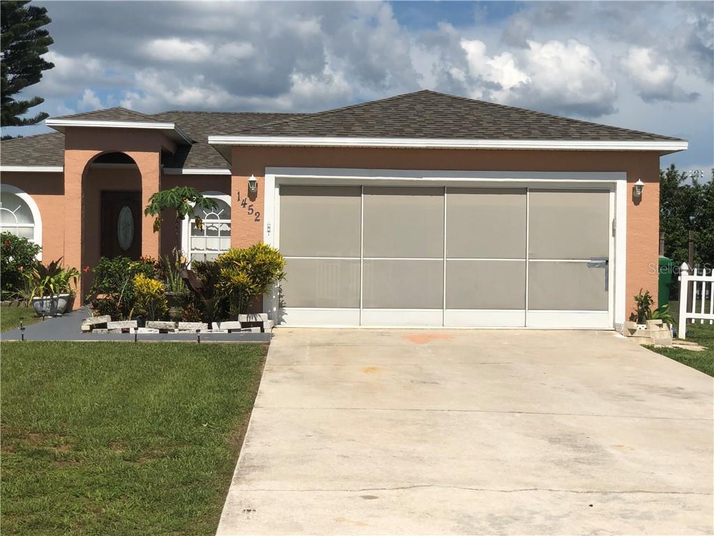 a view of a house with a yard and garage