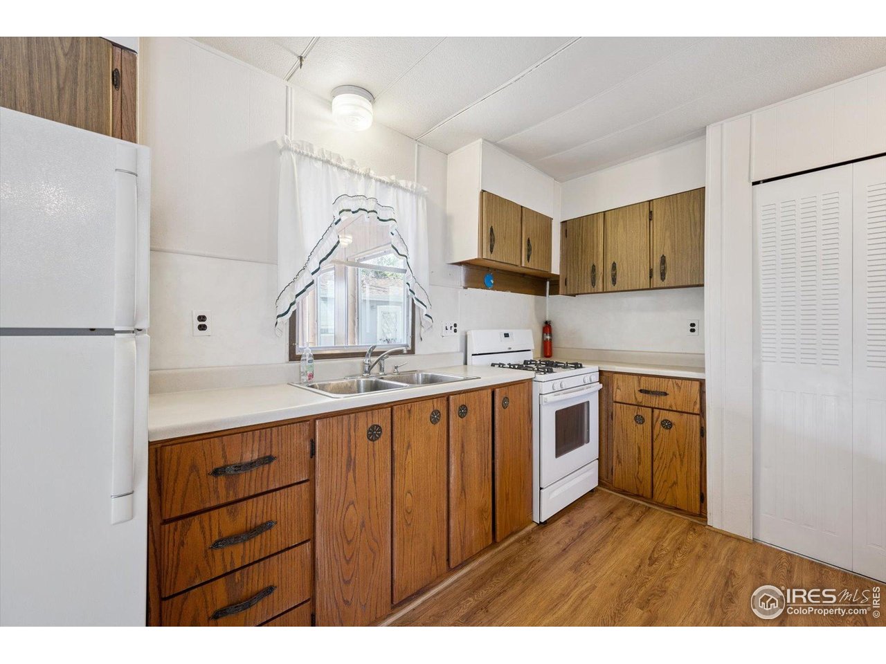 11990 East South Boulder Road, Unit 143 Lafayette, CO 80026 - Photo 6 of 19 a kitchen with white cabinets and white appliances