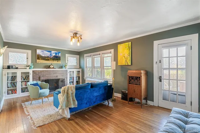 a living room with furniture a fireplace and a floor to ceiling window
