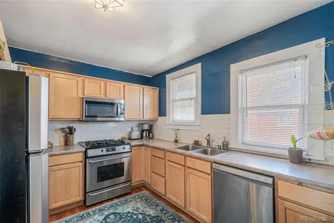 a kitchen with stainless steel appliances a stove sink microwave and cabinets