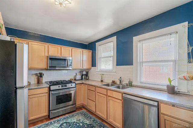 a kitchen with stainless steel appliances a stove sink microwave and cabinets