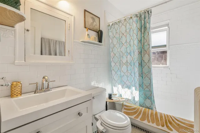 a bathroom with a sink a toilet and shower curtain