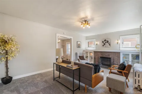 a living room with furniture a fireplace and a potted plant