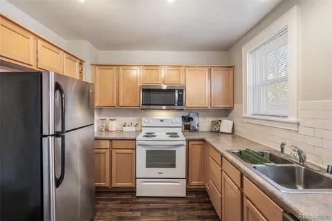 a kitchen with a stainless steel appliances white cabinets and a refrigerator