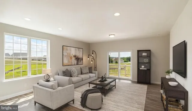 a living room with furniture a window and a flat screen tv