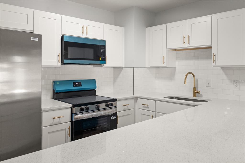 2213 West Ohio Avenue Tampa, FL 33607 - Photo 15 of 21 a kitchen with stainless steel appliances a stove a microwave and sink