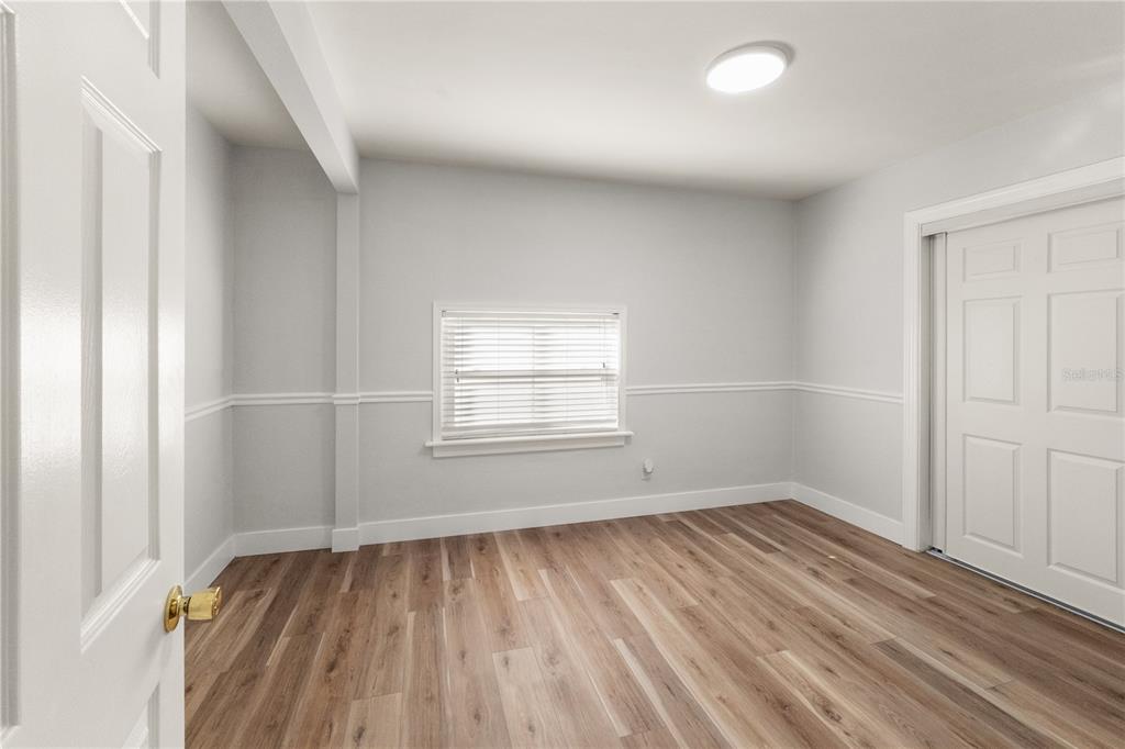 2213 West Ohio Avenue Tampa, FL 33607 - Photo 9 of 21 an empty room with wooden floor and windows