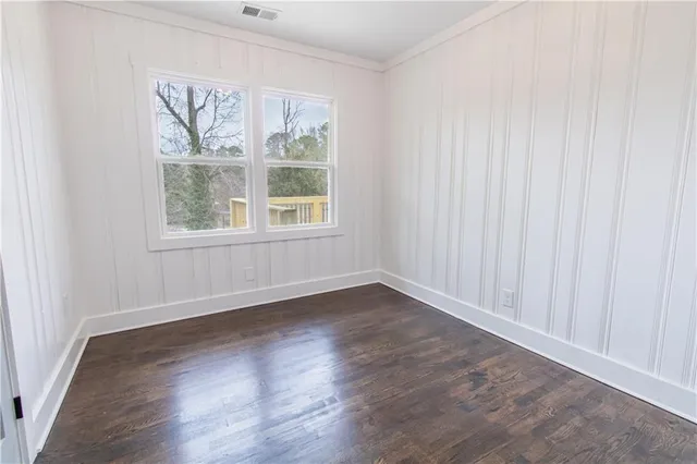 an empty room with wooden floor & closet area