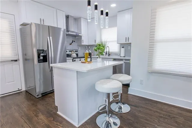 a kitchen with stainless steel appliances granite countertop a sink refrigerator and cabinets
