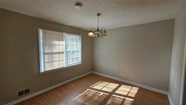 en empty room with windows and chandelier
