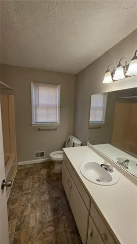 a bathroom with a double vanity sink a mirror and a bathtub