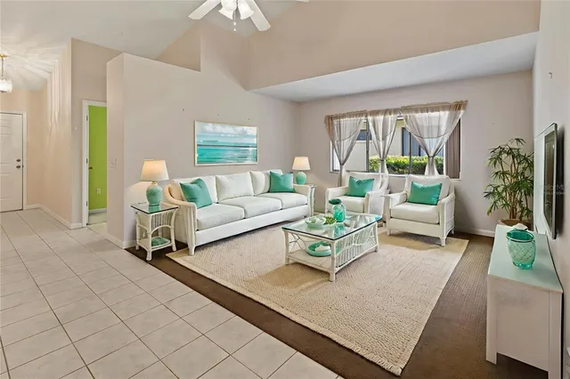 an empty room with a chandelier fan and wooden floor