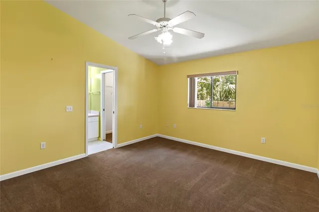 an empty room with a ceiling fan and a window