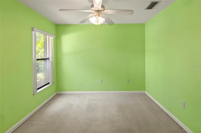 a view of an empty room with window and fan