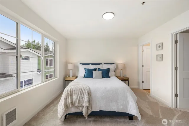 a bedroom with a bed and a large window