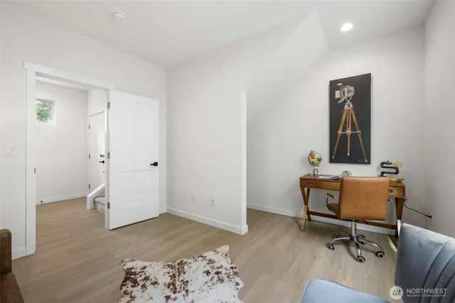 a view of a workspace with furniture and wooden floor