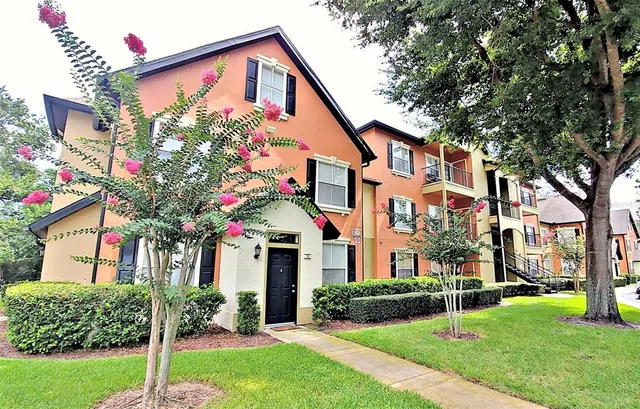 a front view of a house with a yard and trees