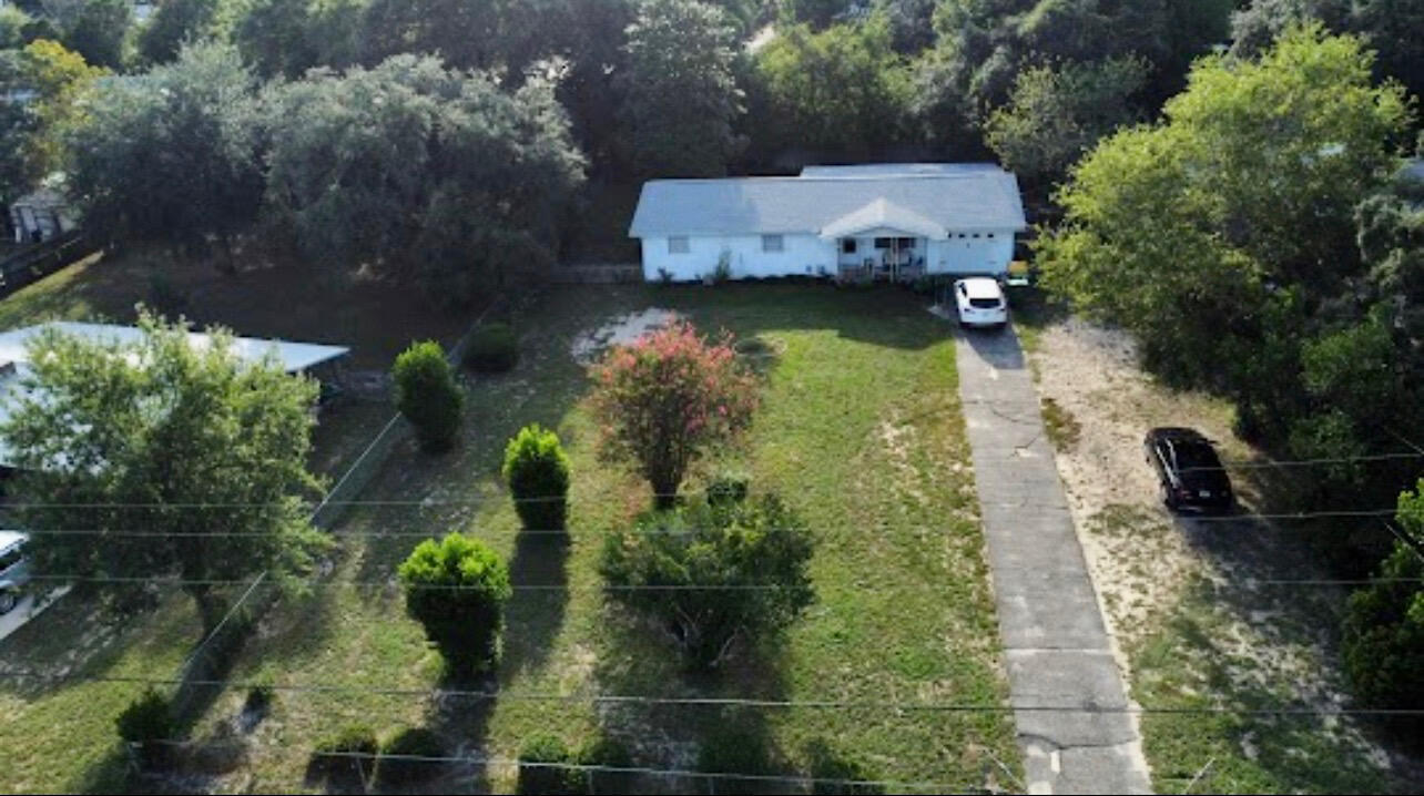 an aerial view of a house with garden space and a street view