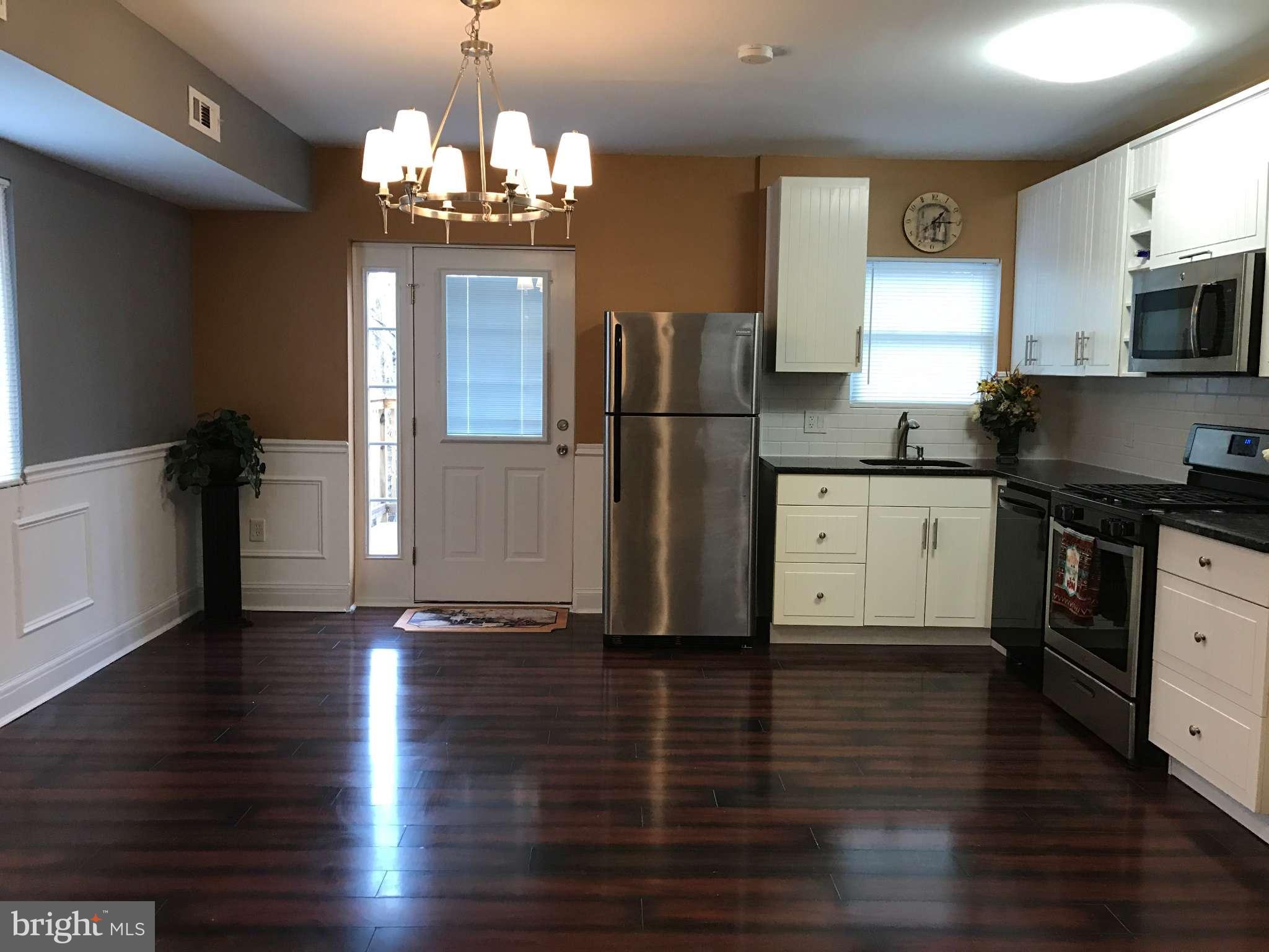3733 Elkader Road Baltimore, MD 21218 - Photo 13 of 26 a kitchen with wooden floors and refrigerator