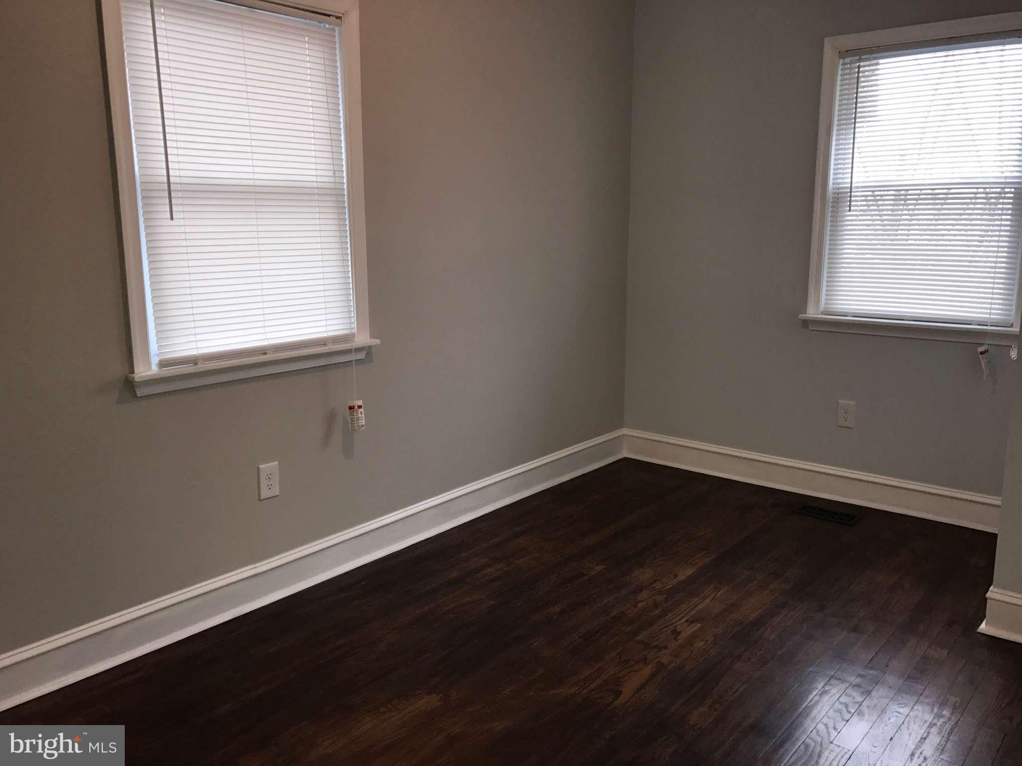 3733 Elkader Road Baltimore, MD 21218 - Photo 18 of 26 an empty room with wooden floor and windows