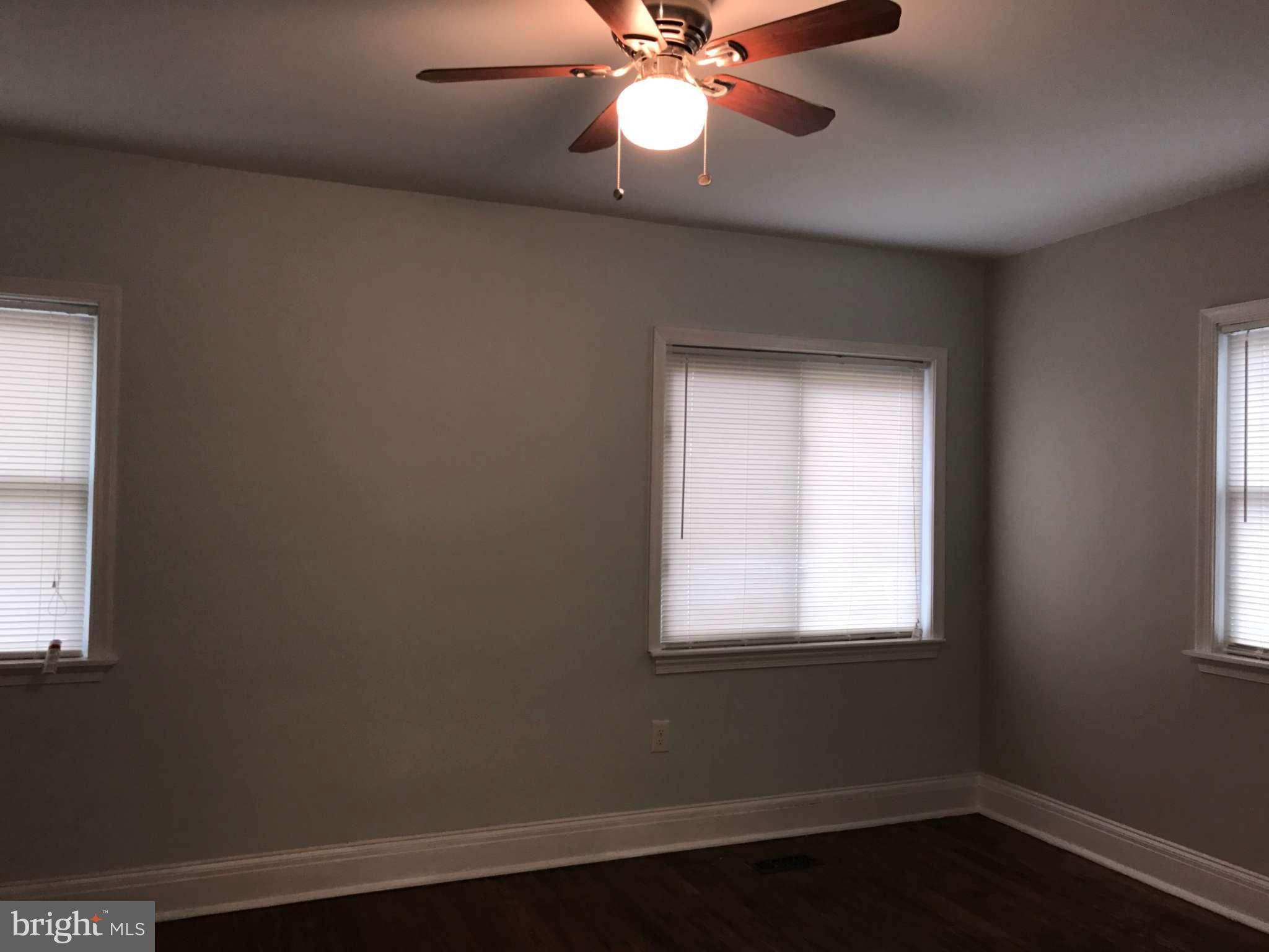3733 Elkader Road Baltimore, MD 21218 - Photo 22 of 26 a view of an empty room with wooden floor and a window