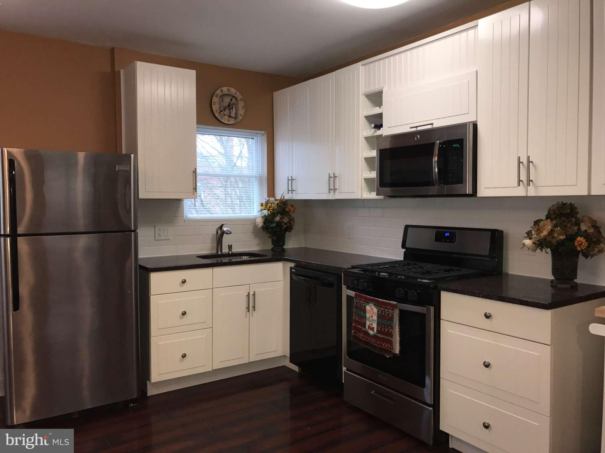 3733 Elkader Road Baltimore, MD 21218 - Photo 26 of 26 a kitchen with granite countertop a refrigerator stove and microwave
