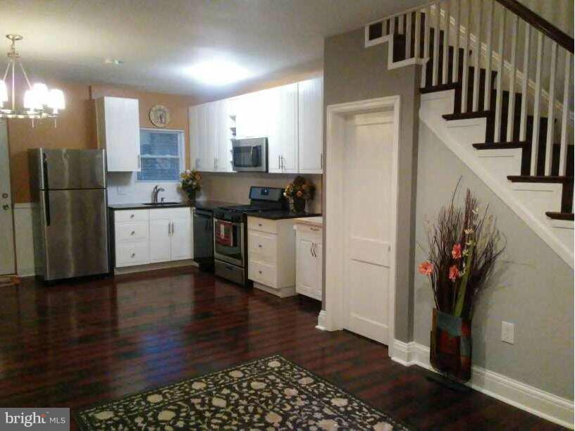 3733 Elkader Road Baltimore, MD 21218 - Photo 4 of 26 a kitchen with granite countertop a refrigerator stove and wooden floor