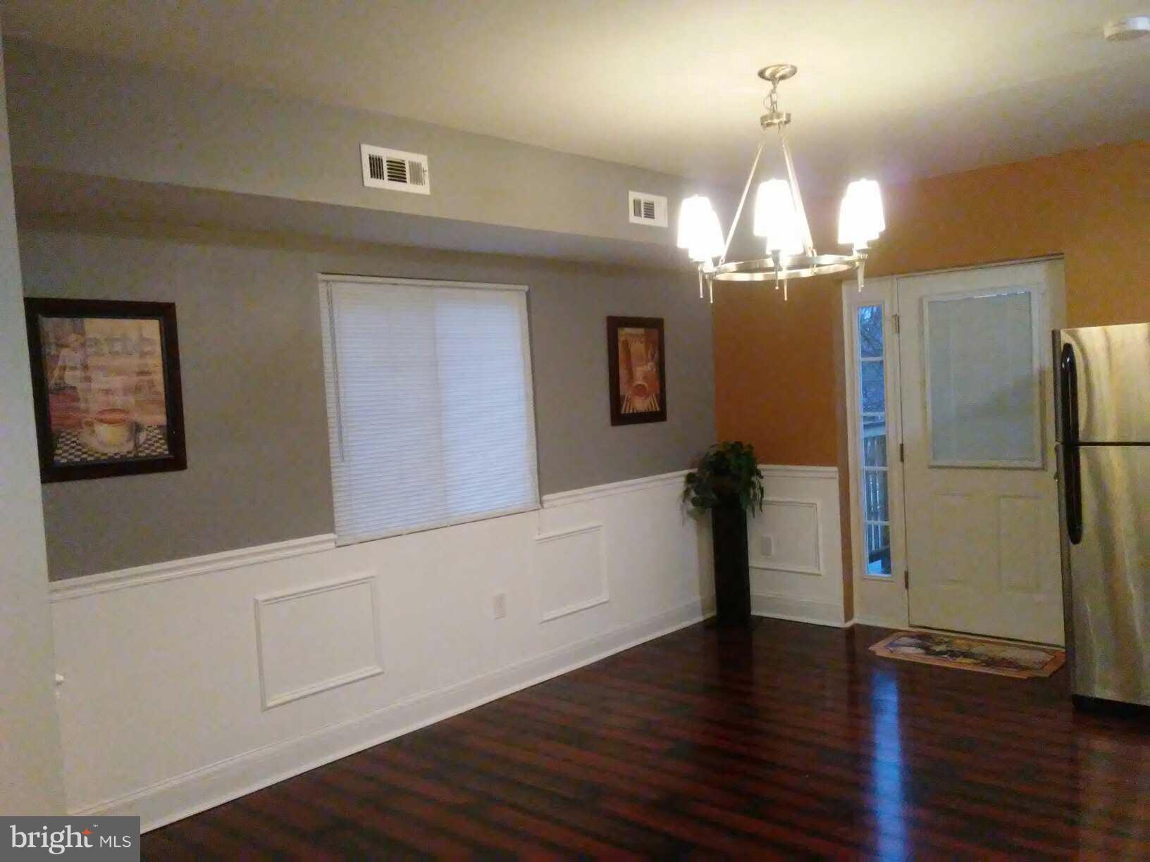 3733 Elkader Road Baltimore, MD 21218 - Photo 5 of 26 a view of a livingroom with wooden floor and chandelier