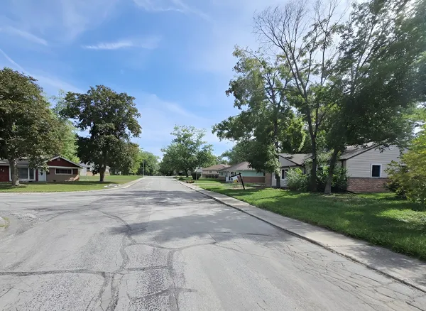 a view of a house with a big yard and large trees