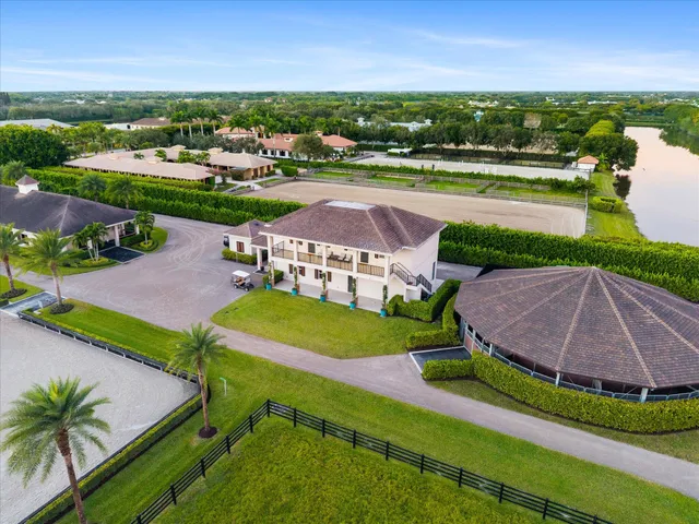 an aerial view of a house with a swimming pool and yard