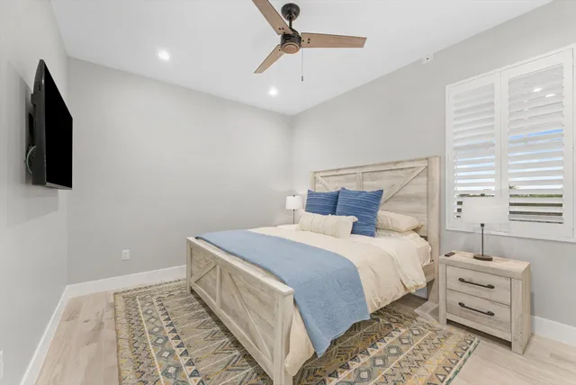 a bedroom with a bed and a flat tv screen on dresser