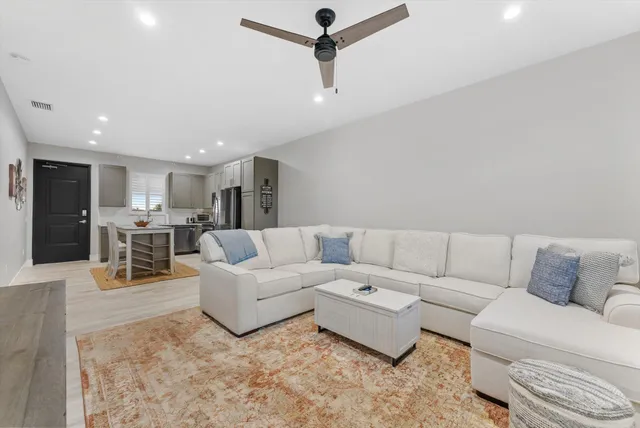 a living room with furniture and kitchen view