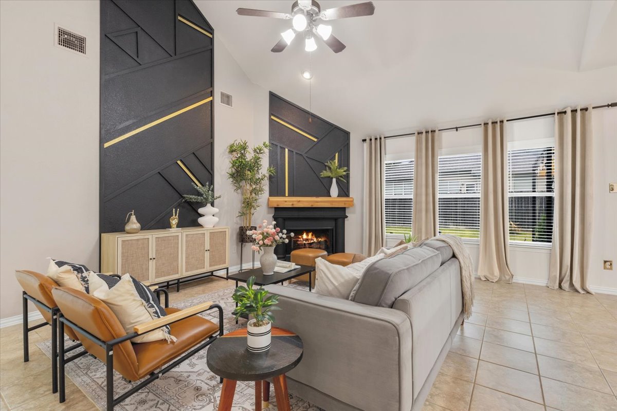 2501 Aspen Meadow Road Leander, TX 78641 - Photo 5 of 30 Vaulted ceilings define this spacious living area featuring a fireplace with a wood mantle and decorative wall panels